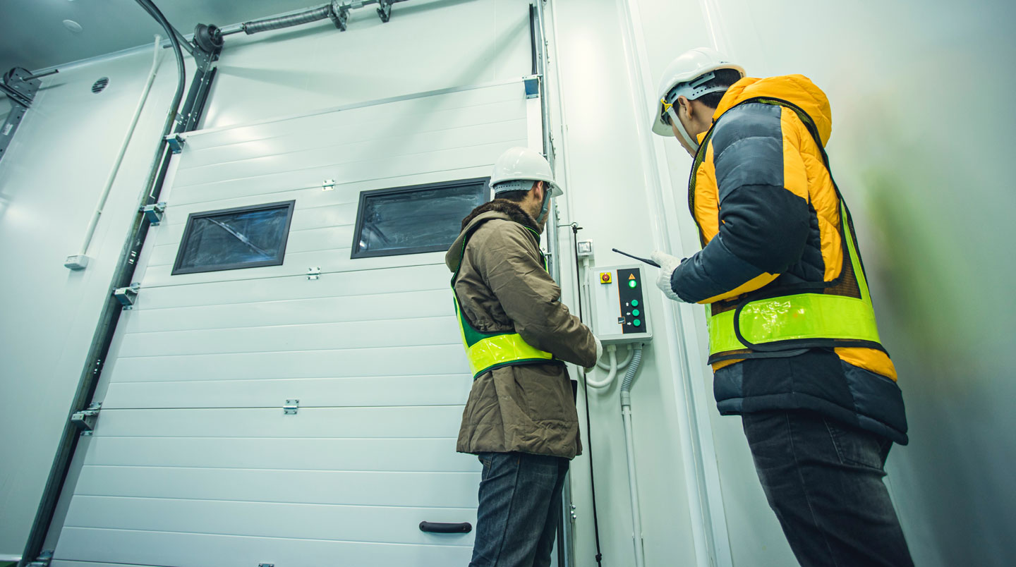 Technicien ajustant un capteur de détection sur un passage industriel